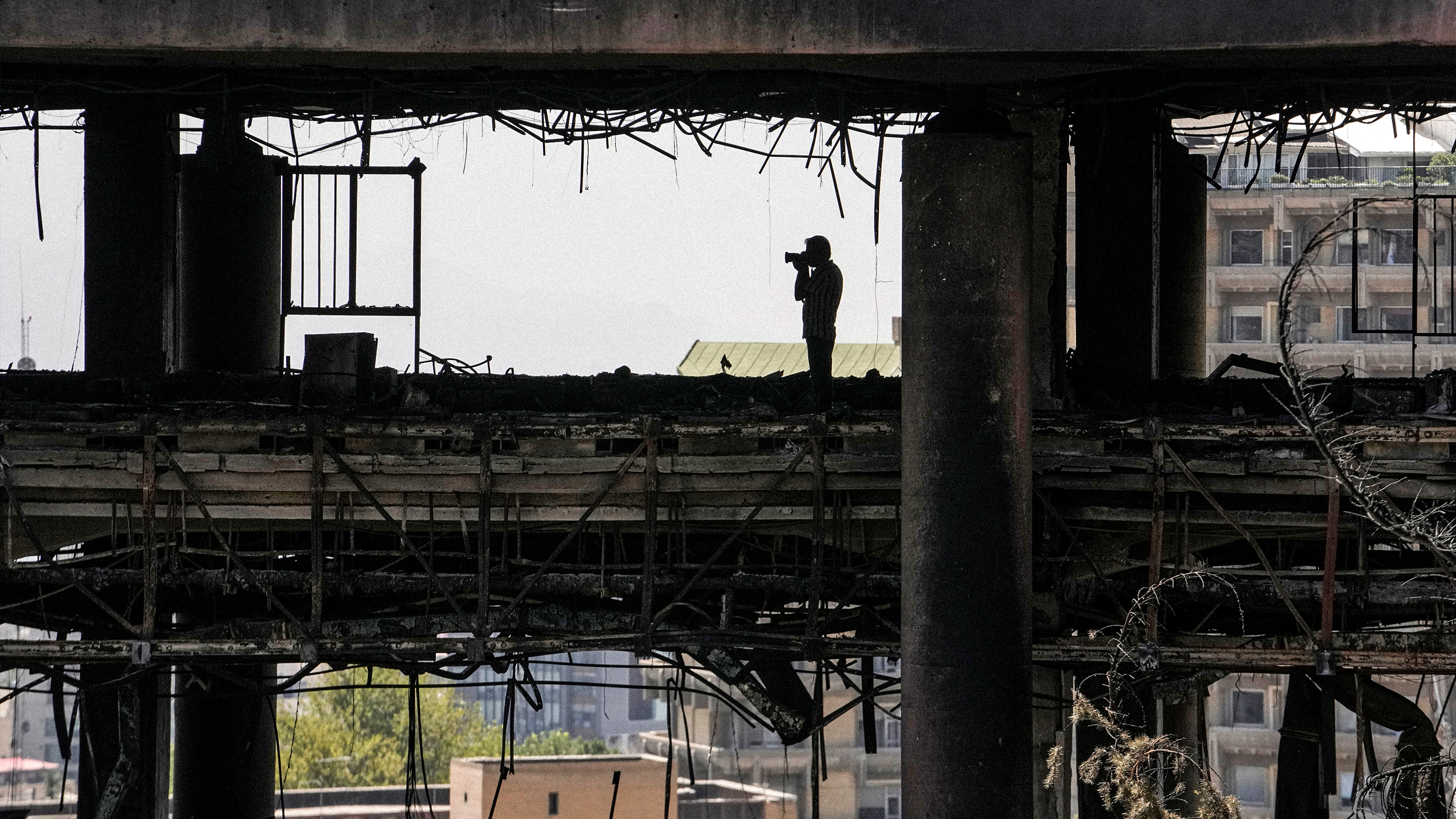 En fotojournalist tar bilder på iranska statstelevisionens huvudkvarter som bombats i kriget mellan Israel och Iran. 