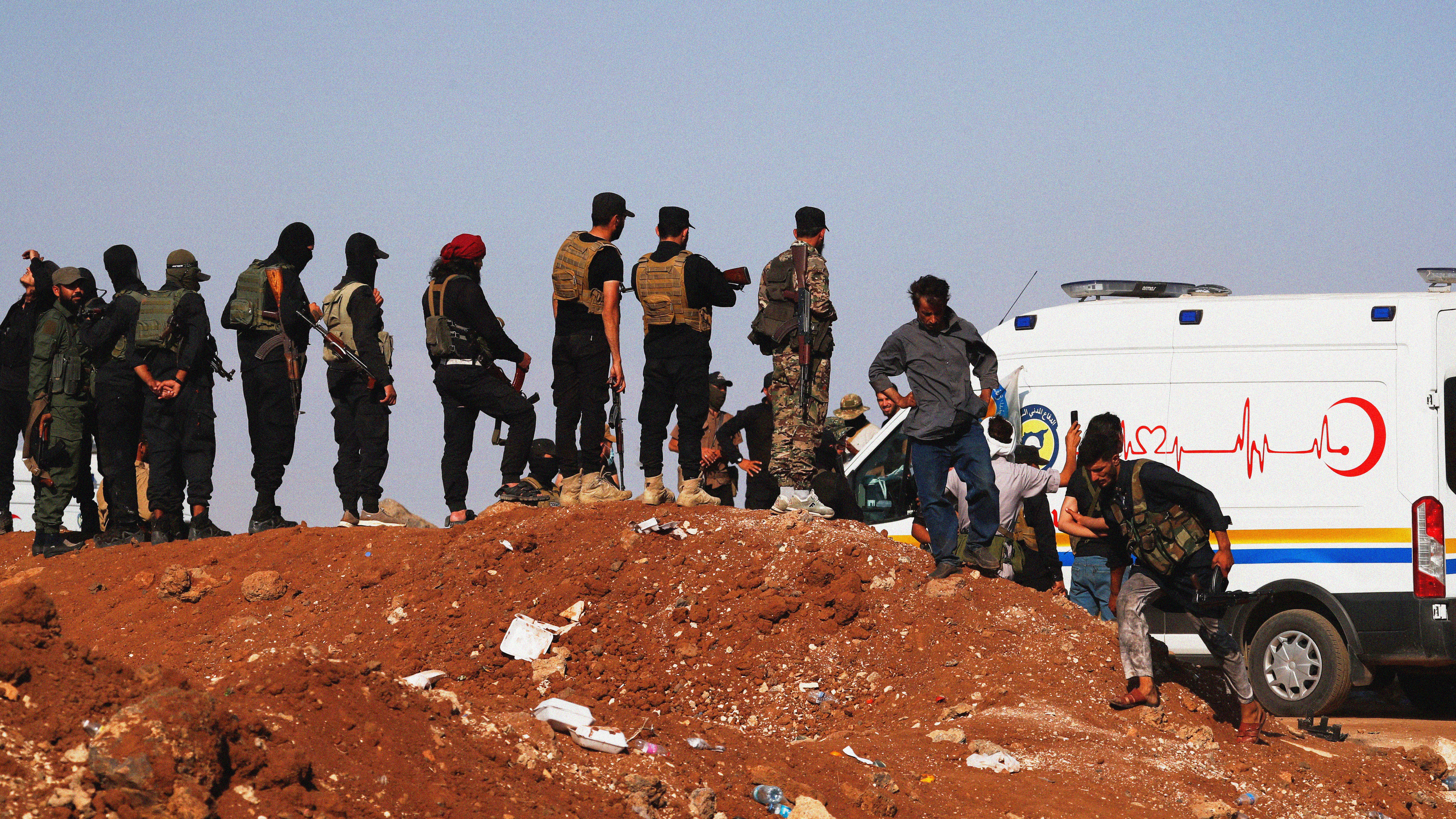 Ambulanser och bussar anländer till en kontrollpunkt i byn Busra al-Harir, södra Syrien, på väg till Sweida-provinsen, samtidigt som säkerhetsstyrkor spärrar av området för att hindra beduinska krigare från att komma in i provinsen, 22 juli 2025.