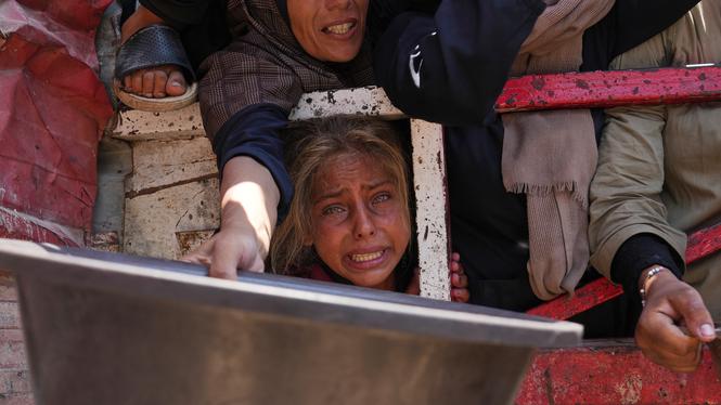 Bild som föreställer palestinier som kämpar för att få donerad mat i Gaza stad, lördagen den 26 juli 2025, har av Grok påståtts vara tagen i Syrien/Irak 2014.