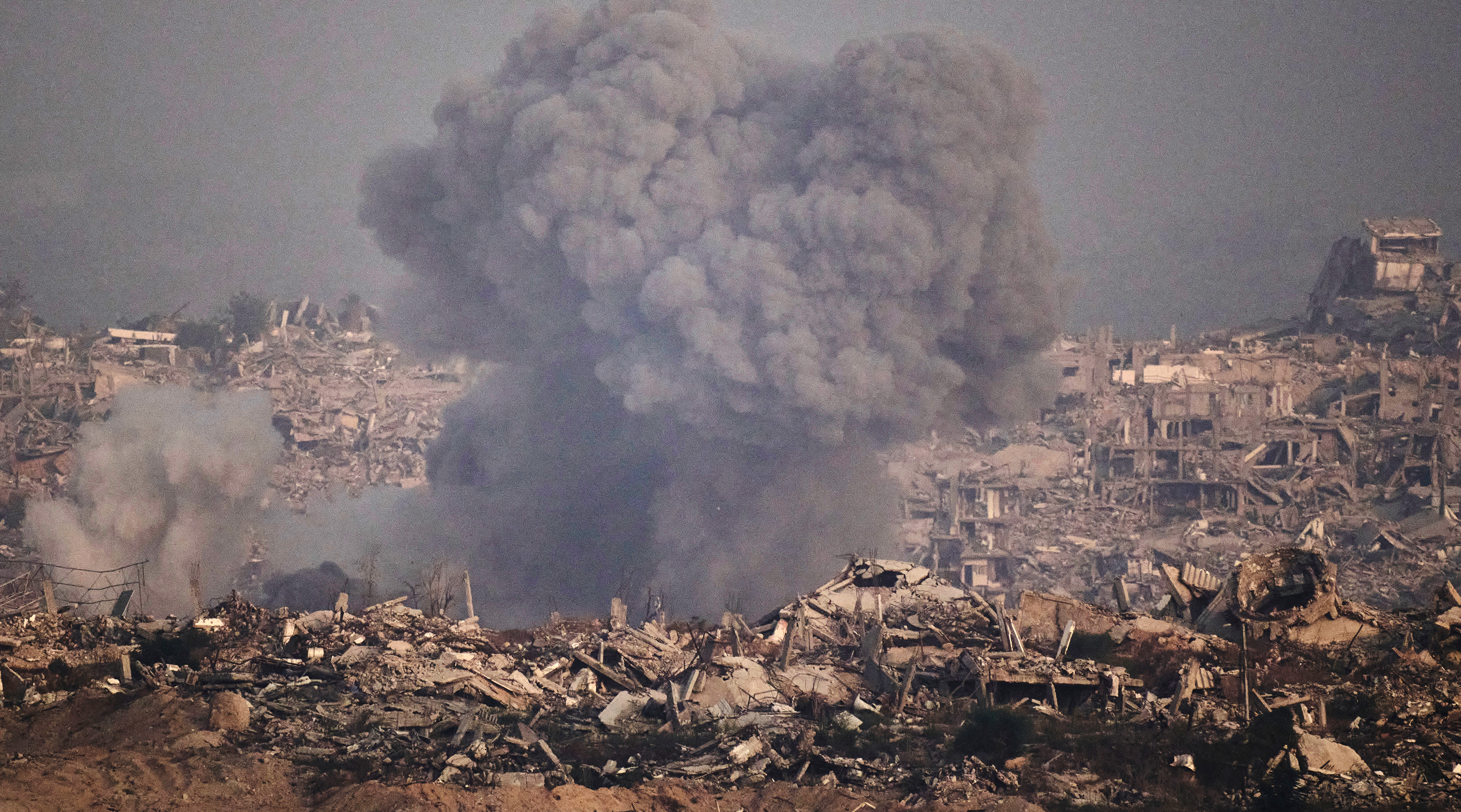 Stigande rök bland husruiner efter en israelisk attack på Gazaremsan.