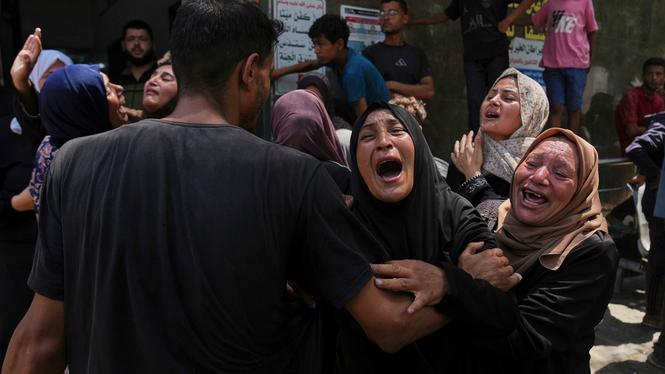 Traji Adwan, i mitten, sörjer begravningen av sitt 11-åriga barnbarn Qais, som dödades i en israelisk flygattack mot en skola i Gaza som har använts som skydd.