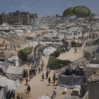 Palestinier rusar för mot luftburna nödhjälpssändningar som släppts över Gaza stad. Bilden är från i torsdags. 