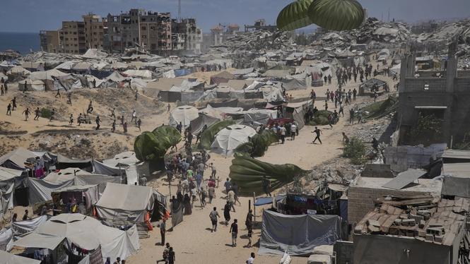 Palestinier rusar för mot luftburna nödhjälpssändningar som släppts över Gaza stad. Bilden är från i torsdags. 