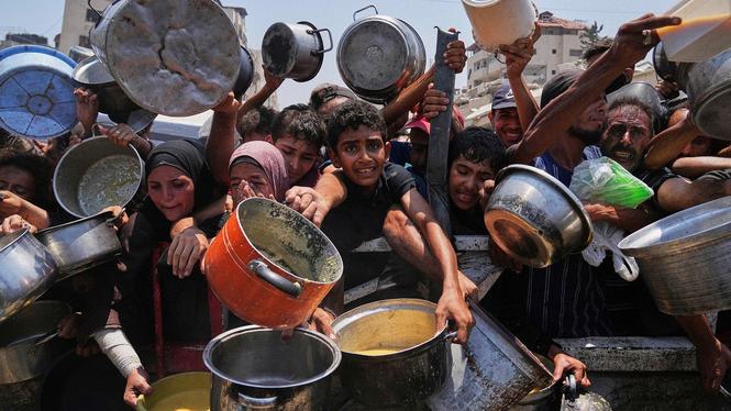 Palestinier kämpar för att få mat under en matutdelning i Gaza stad, juli 2025.