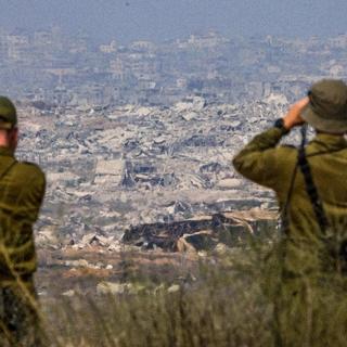 Israelisk militär blickar över ett sönderbombat Gaza. Enligt uppgifter försöker Egypten och Qatar få till en vapenvila mellan Israel och Hamas.