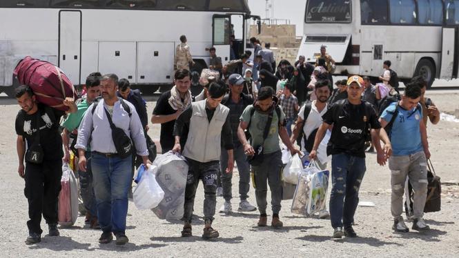 Afghanska flyktingar som tvingats tillbaka hem vid gränsövergången Islam Qala mellan Iran och Afghanistan. Bild tagen 20 juni.