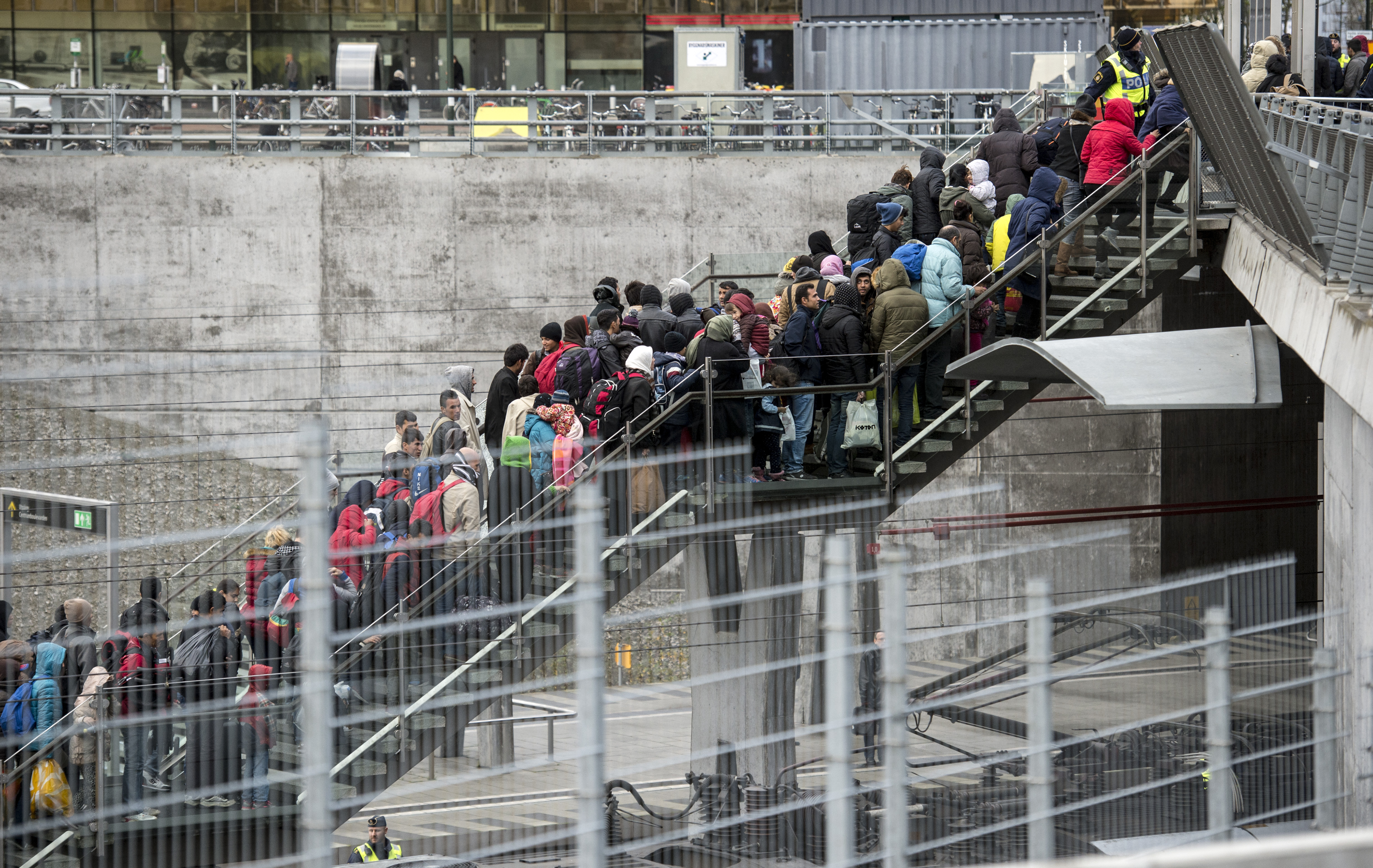 Polis övervakar kön av ankommande flyktingar i snålblåsten vid Hyllie station i Malmö, november 2015. 