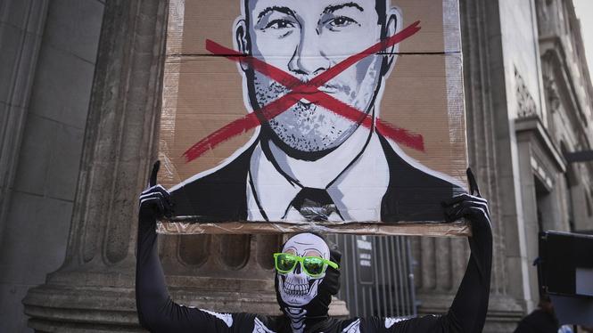En demonstrant håller upp en bild på Jimmy Kimmel utanför byggnaden där komikerns pratshow spelas in i Los Angeles.