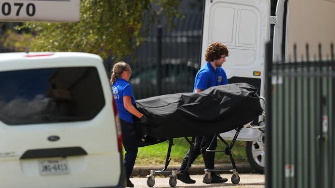 Kroppen till den misstänkta skytten förs bort efter att han skjutit sig själv efter att ha skjutit tre personer vid migrationskontoret i Dallas, USA.
