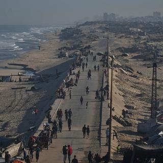 Fördrivna palestinier promenerar längs vattnet efter att fredsavtalet skrivits på. Israeliska styrkor ska nu har börjat retirera.