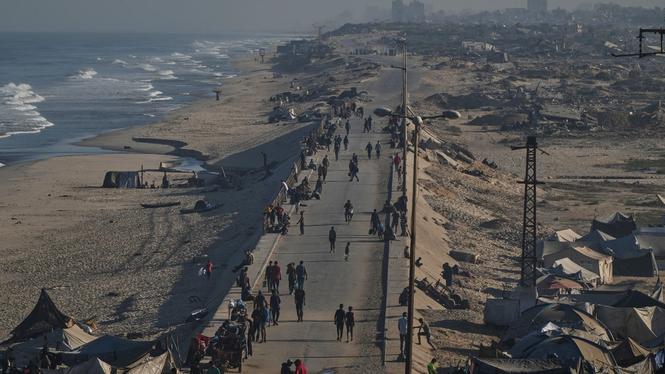 Fördrivna palestinier promenerar längs vattnet efter att fredsavtalet skrivits på. Israeliska styrkor ska nu har börjat retirera.