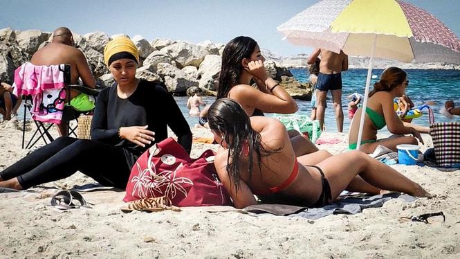 En fransk kvinna i burkini på stranden med vänner 2016.