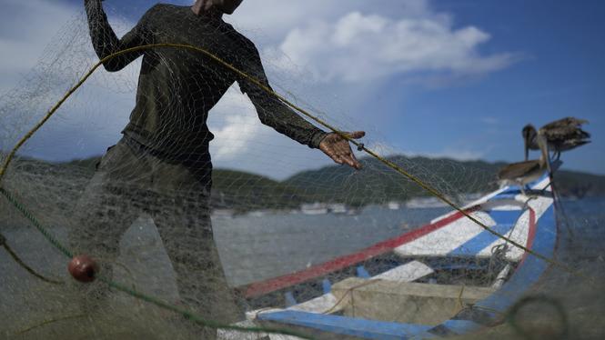 En fiskare förbereder sitt nät i El Morro de Puerto Santo i Venezuela, ett av de fiskesamhällen i området där den lokala ekonomin också inbegriper transporter av narkotika.