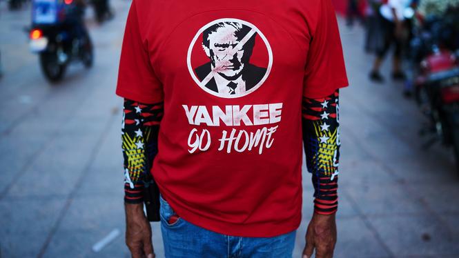 En man har en tröja som skickar en signal mot utländsk inblandning i politiken i Venezuela under en protest i torsdags i Caracas.