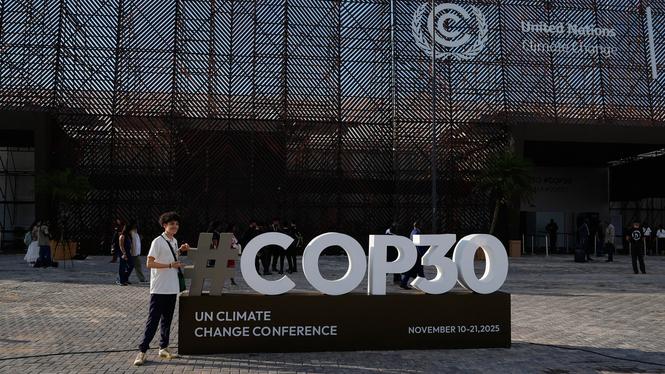 En person poserar för ett foto utanför för FN:s klimattoppmöte COP30 i Belém, Brasilien.