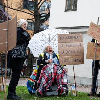 Kerstin Johansson, med paraplyet, är initiativtagare till demonstrationen. Hon säger att hon hoppas att de kommer att kunna påverka politikerna här i dag.