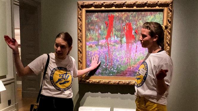 Två aktivister från Återställ våtmarker limmar fast sig vid en Monet-tavla på Nationalmuseum, Stockholm.
