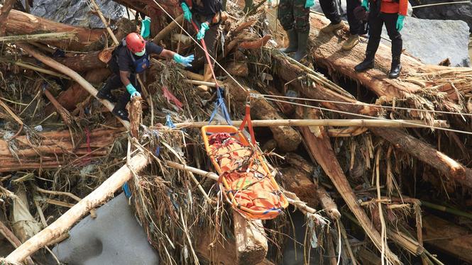 Ett offer för översvämningarna på den indonesiska ön Sumatra evakueras med hjälp av rep på måndagen.