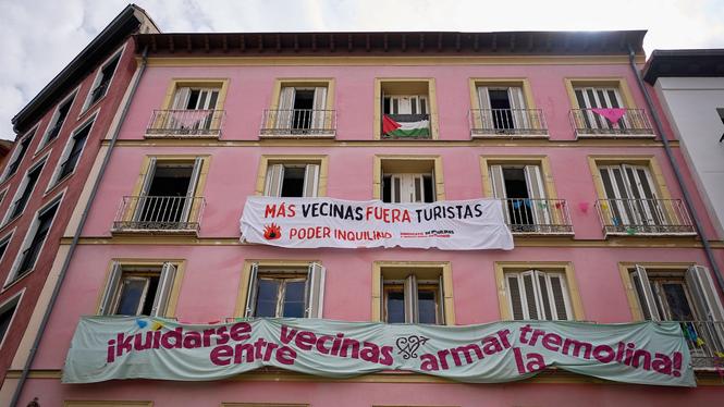 En husfasad i Madrid pryds av band­eroller mot lägenhetshotell, i juni 2025.