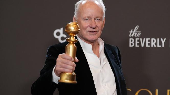 Stellan Skarsgård poserar med sin Golden Globe-statyett i pressrummet.