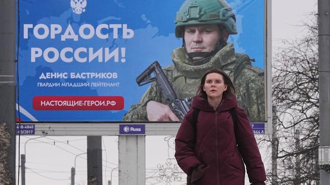 En kvinna går förbi en reklamskylt som visar en rysk soldat med texten ”Rysslands stolthet”, i Sankt Petersburg, Ryssland. Ryssland är nu inne på det femte året i sitt krig mot Ukraina.