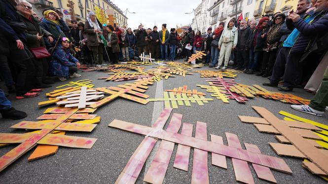 Demonstration mot de miljöskadliga effekterna av de olympiska vinterspelen i Italien. Pappgranarna representerar de träd som fälldes under bygget av en ny bob-bana.