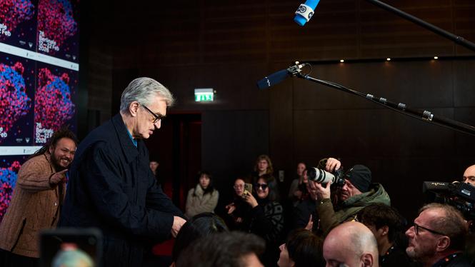 Juryns ordförande, regissören Wim Wenders skriver autografer efter en presskonferens i Berlin under filmfestivalen.