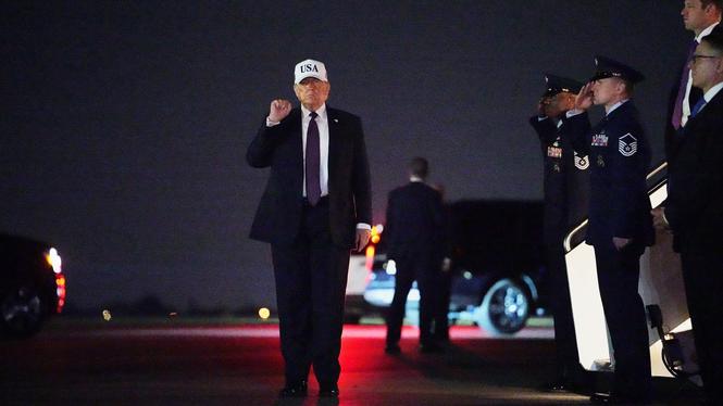 USA:s president Donald Trump höjer näven i luften efter att ha landat i Florida på fredagskvällen.