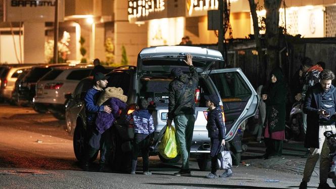 En familj lämnar sitt hem i samband med israeliska luftattacker mot Beiruts södra förorter.