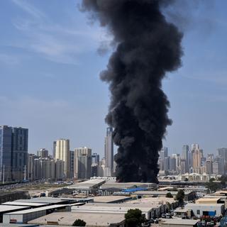 Ett svart rökmoln stiger från ett lager i industriområdet i Sharjah City, Förenade Arabemiraten, efter rapporter om iranska attacker i Dubai.