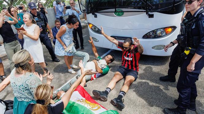 Demonstranter försöker stoppa en buss som tros transportera Irans damlandslag i fotboll när den lämnar ett hotell på Gold Coast i Australien.