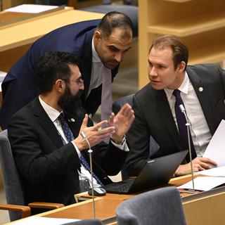 Avhoppade M-ledamoten Arin Karapet i samspråk med Rashid Farivar (SD) och Markus Wiechel (SD) i riksdagen. 
