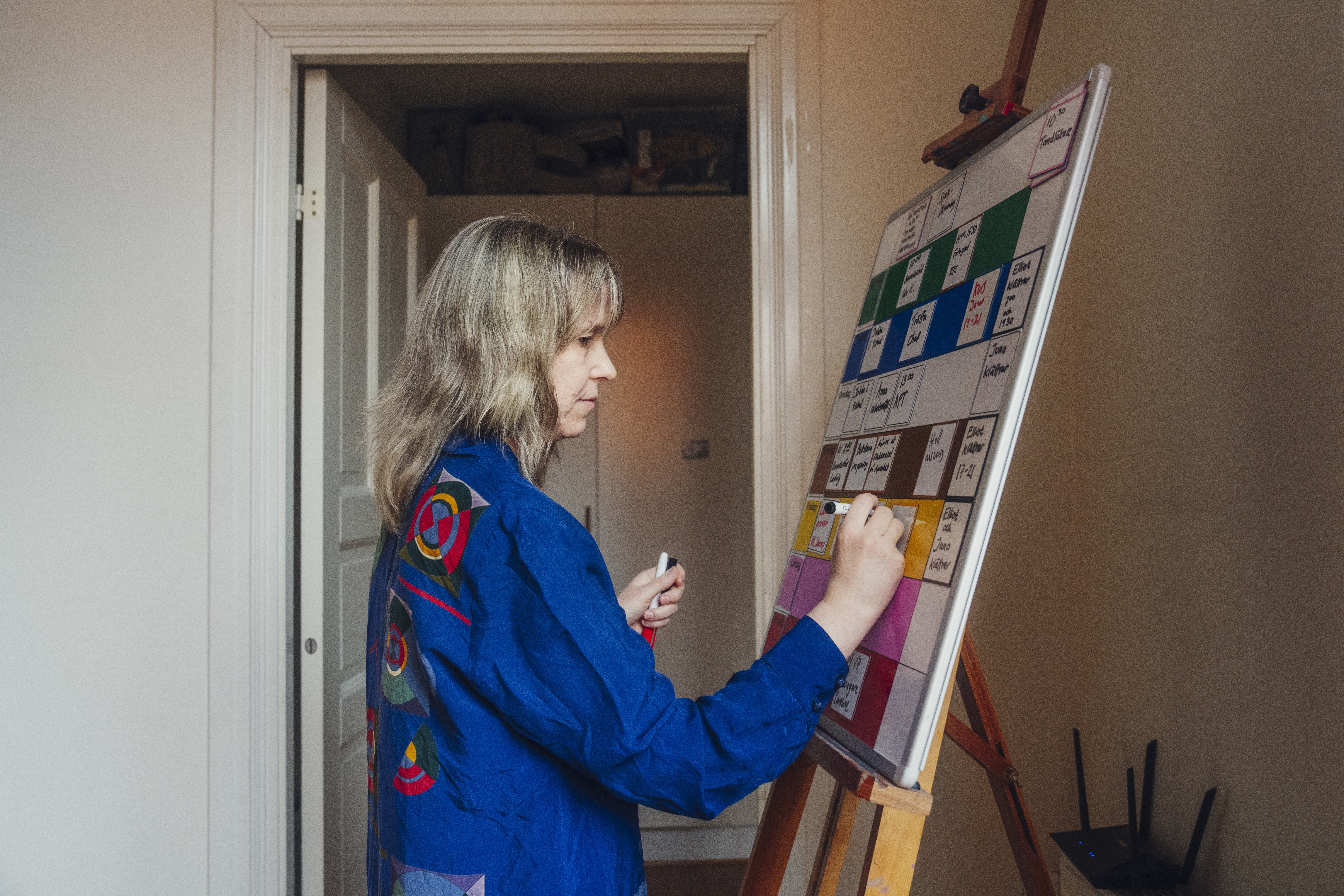Anna-Maria Olofsgård fyller i sin veckotavla med kom ihåg-skyltar.