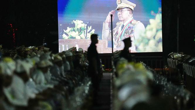 Myanmar styrs sedan 2021 av överbefälhavare Min Aung Hlaing, som tog makten i en militärkupp 2021. Här ses han på storbildsskärm med paraderande soldater framför sig.