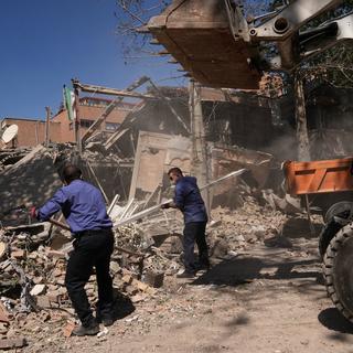 Män arbetar med att få undan rasmassor vid ett universitet i Teheran som träffats i en amerikansk-israelisk attack den 6 april.