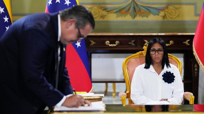 Mariano Vela, en representant för oljejätten Chevron, undertecknar ett avtal som tillåter företaget att utöka sina oljeborrningar i Venezuela. Tillförordnade presidenten Delcy Rodríguez tittar på.