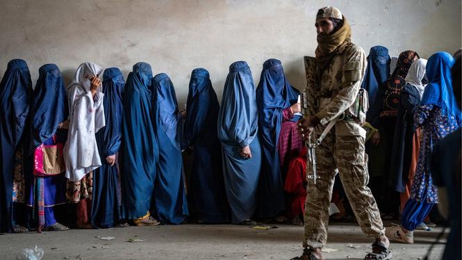 Talibankrigare framför en grupp kvinnor i Kabul.