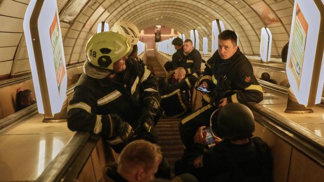 Brandmän tar skydd i Kievs tunnelbana under en robotattack natten mot söndagen.