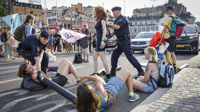 Poliser för bort klimataktivister som upprättat en vägspärr vid Slussen i Stockholm 2022.