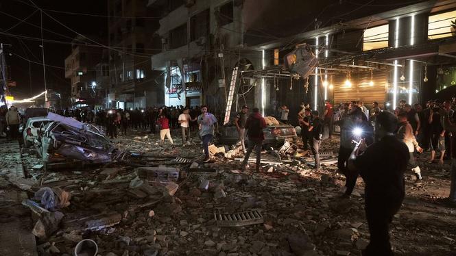 Palestinier på platsen för ett israeliskt luftanfall mot Gaza stad på tisdagen.