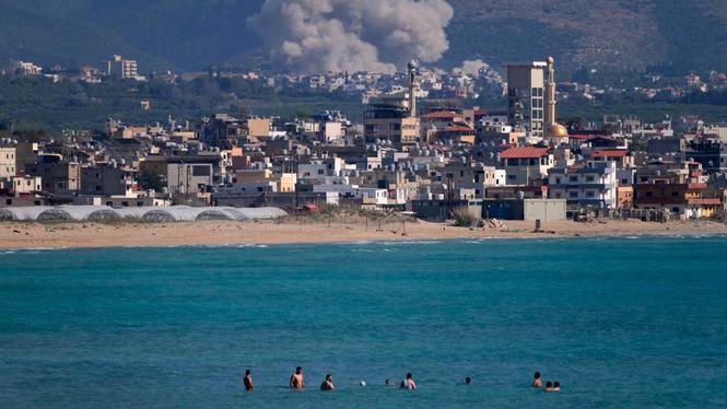 Människor simmar utanför kuststaden Sour i södra Libanon, samtidigt som Israel bombar. Bilden är tagen den 2 juni 2026.