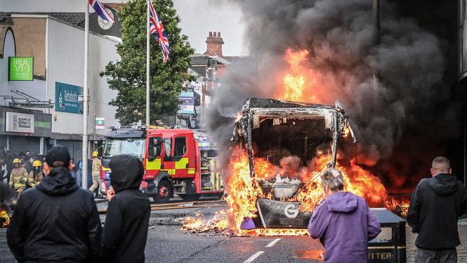 En buss står i brand i Belfast under tisdagskvällen. Upploppen fortsatte in på natten.