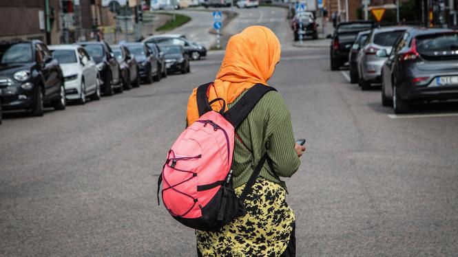 Kvinna med slöja promenerar på allmän plats. Arkivbild.