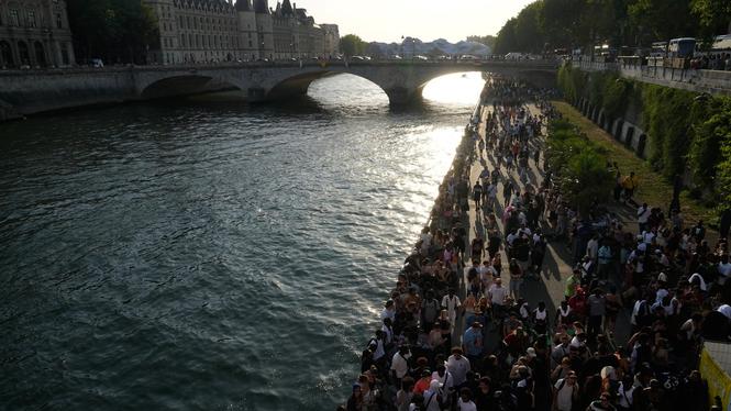 Människor går efter floden Seine i Paris i hettan på söndagen. 
