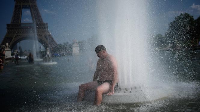 En man kyler ned sig i en fontän i Paris på onsdagen.