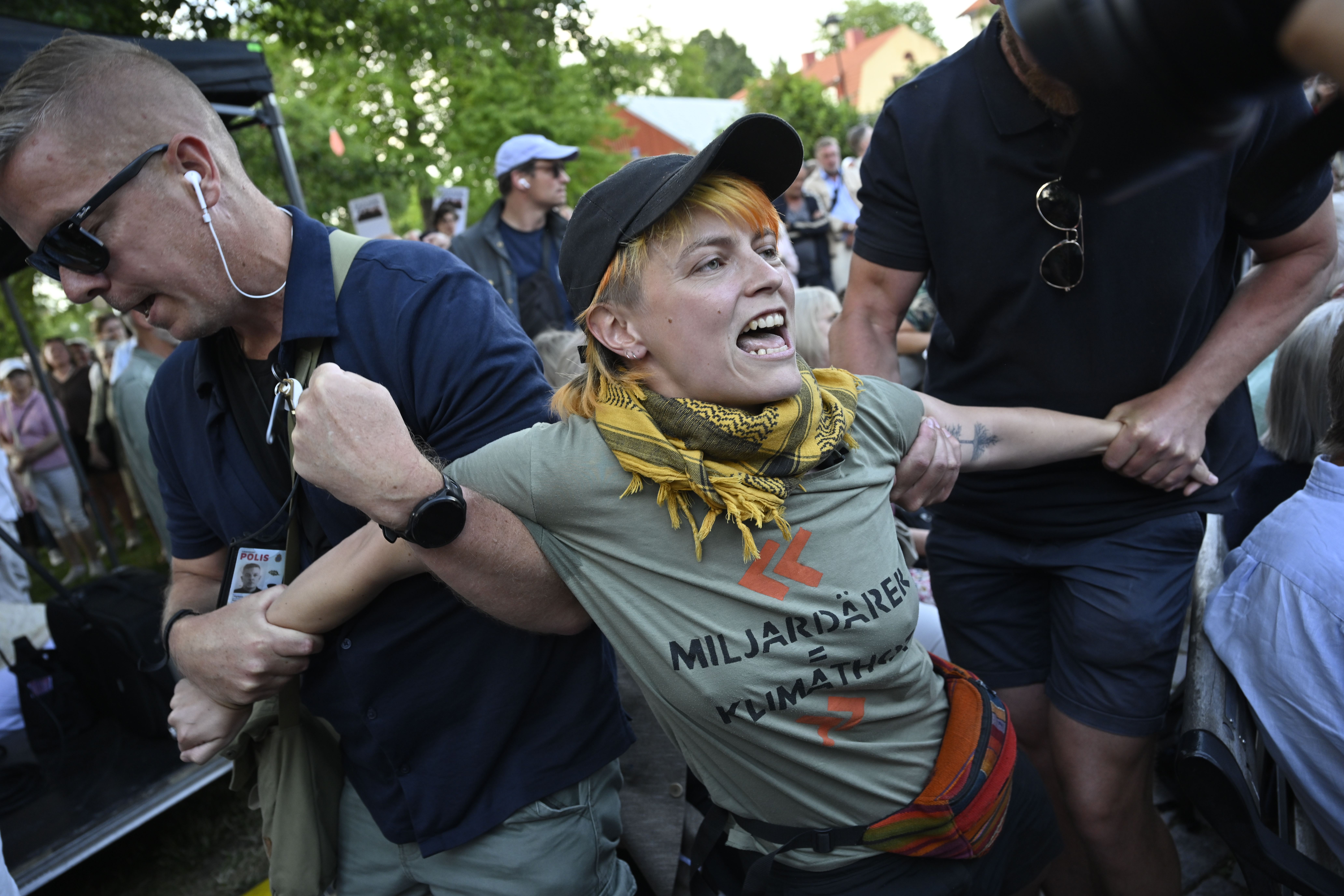 Vakter för bort personer som protesterar när Socialdemokraternas partiledare Magdalena Andersson (S) börjar sitt tal under Almedalsveckan.