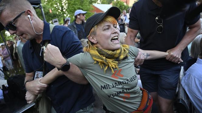 Vakter för bort personer som protesterar när Socialdemokraternas partiledare Magdalena Andersson (S) börjar sitt tal under Almedalsveckan.